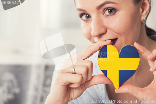 Image of Young woman with gingerbread heart cookies with flag