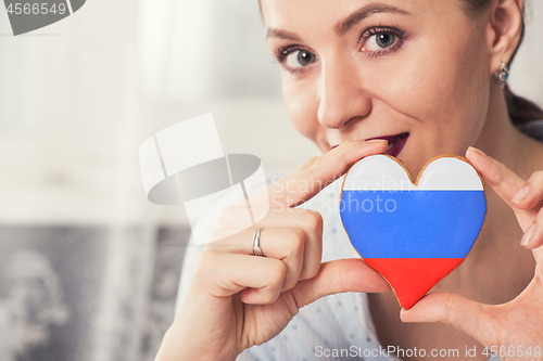 Image of Young woman with gingerbread heart cookies with flag