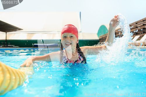 Image of The portrait of happy smiling beautiful teen girl at the pool