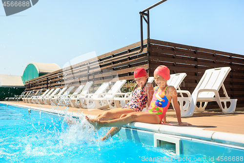 Image of The portrait of happy smiling beautiful teen girls at the pool