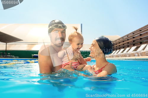 Image of Happy family having fun by the swimming pool