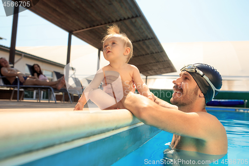 Image of Happy family having fun by the swimming pool