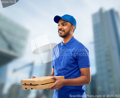 Image of happy indian delivery man with pizza boxes in blue