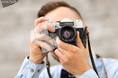 Image of photographer with film camera making shot