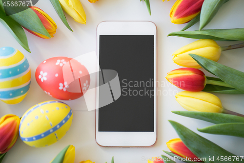 Image of smartphone with easter eggs and tulip flowers