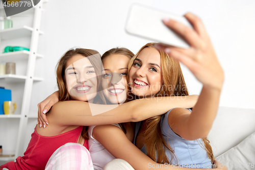 Image of teenage girls taking selfie by smartphone at home