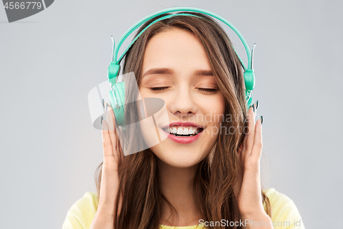 Image of happy young woman or teenage girl with headphones