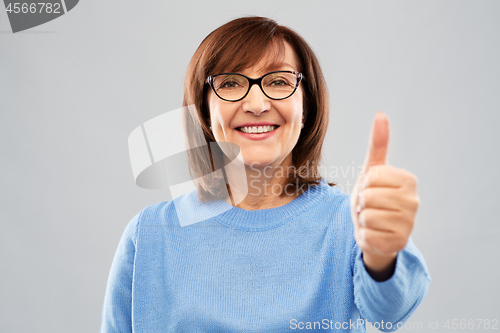 Image of portrait of senior woman showing thumbs up