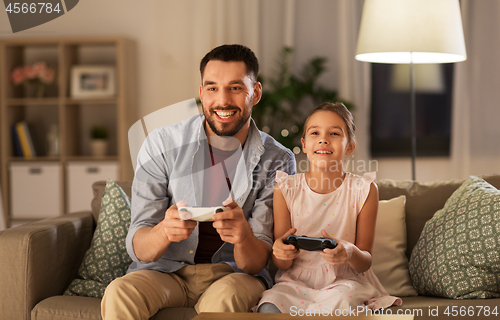 Image of father and daughter playing video game at home