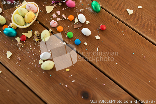 Image of chocolate egg and candy drops on wooden table