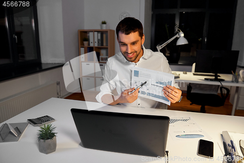 Image of businessman having video chat at night office