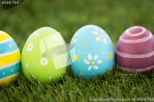 Image of row of colored easter eggs on artificial grass