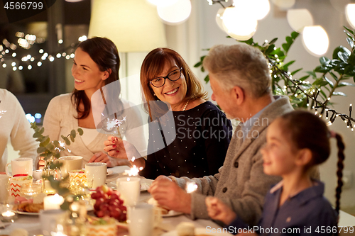 Image of family with sparklers having tea party at home