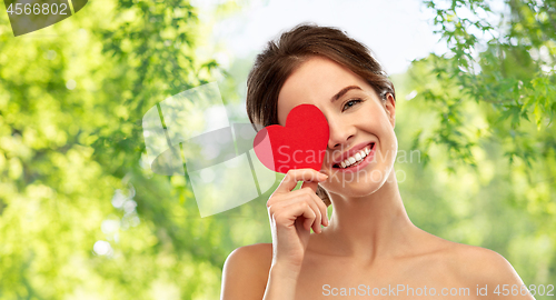 Image of beautiful smiling woman holding red heart