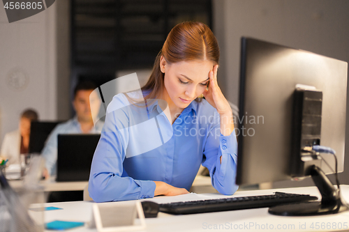 Image of businesswoman with computer at night office