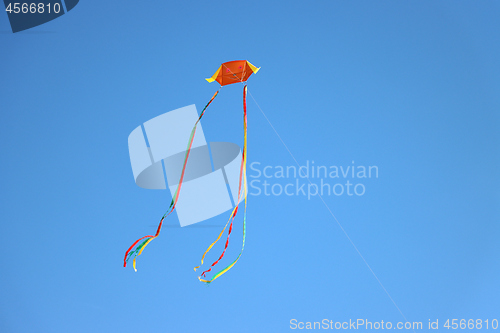 Image of Colorful kite flying and blue sky as background