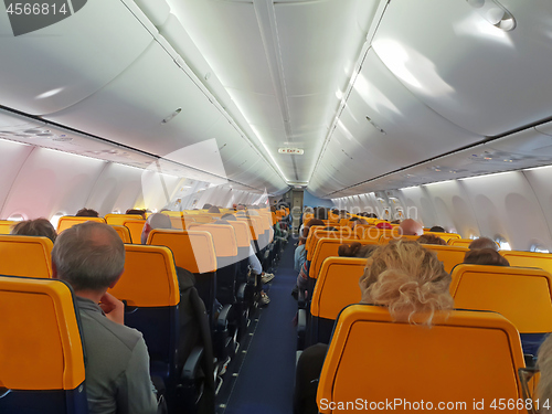 Image of People are sitting in an airplane cabin during flight