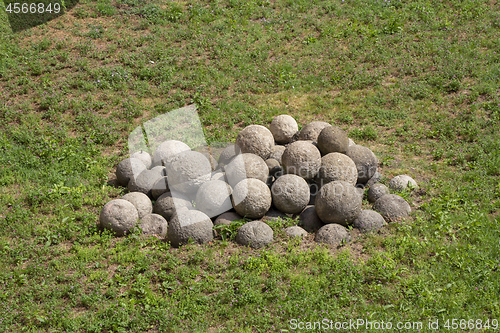 Image of Old iron cannon balls on green grass