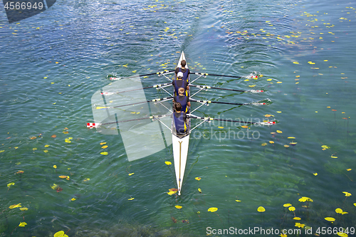 Image of Men's quadruple rowing team on turquoise green lake