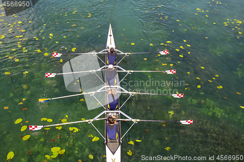 Image of Men's quadruple rowing team on turquoise green lake