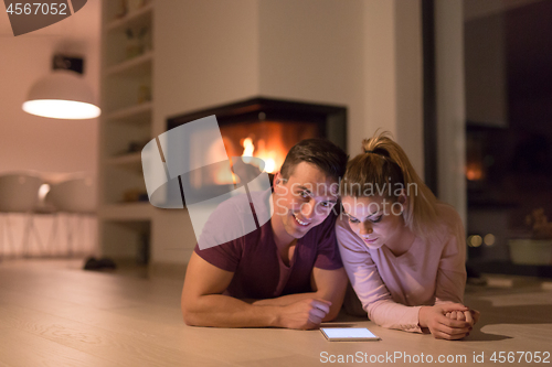 Image of Young Couple using digital tablet on cold winter night