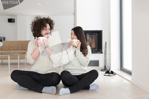 Image of happy multiethnic couple  in front of fireplace