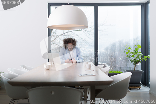 Image of Young casual businessman using smartphone