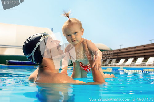 Image of Happy family having fun by the swimming pool