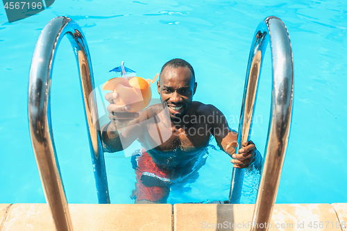 Image of The portrait of happy smiling beautiful man at the pool