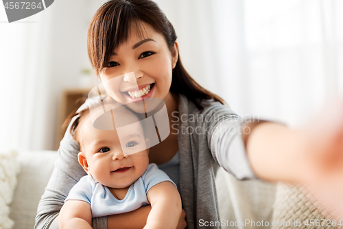 Image of happy mother with little baby son taking selfie