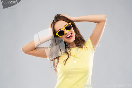 Image of teenage girl in yellow sunglasses and t-shirt