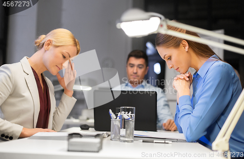 Image of business team with laptop working late at office