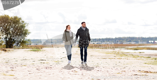 Image of couple walking along autumn beach