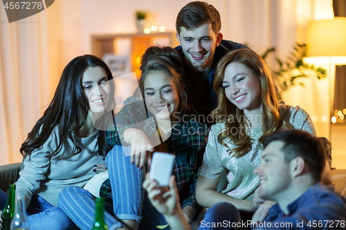 Image of friends with smartphone watching tv at home