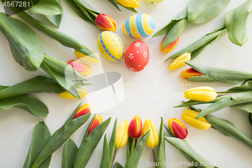 Image of close up of colored easter eggs and tulip flowers