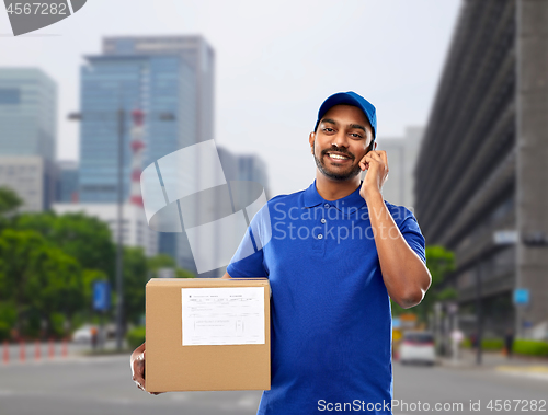 Image of indian delivery man with smartphone and parcel box