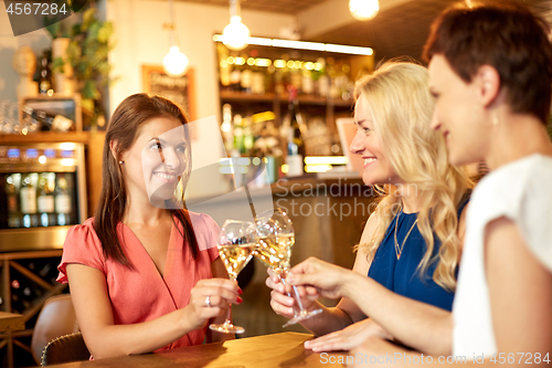 Image of happy women drinking wine at bar or restaurant