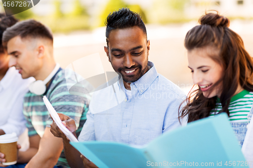 Image of international students with notebooks outdoors