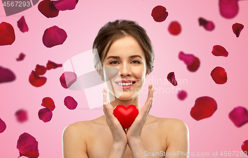 Image of beautiful smiling woman holding red heart