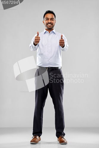 Image of smiling indian businessman showing thumbs up