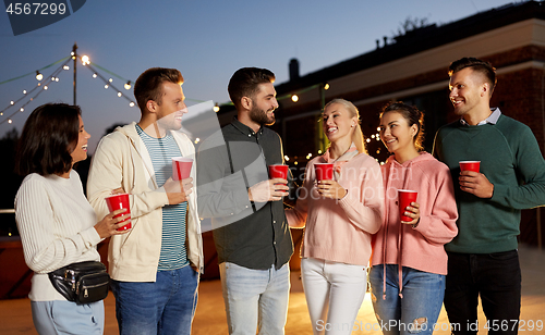 Image of friends with drinks at rooftop party