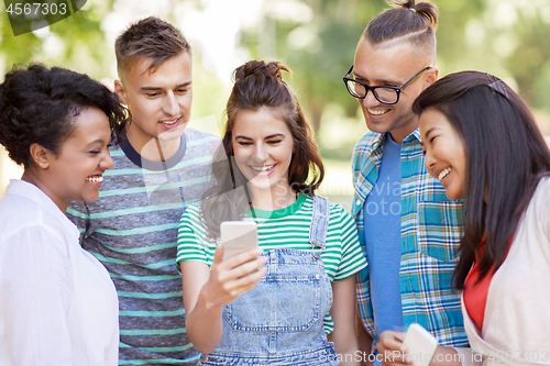 Image of group of happy friends with smartphone outdoors
