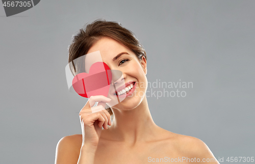 Image of beautiful smiling woman holding red heart