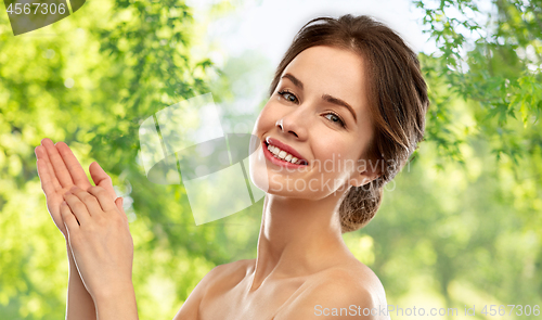Image of smiling young woman over grey background