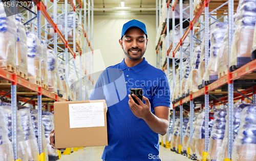 Image of delivery man with smartphone and box at warehouse