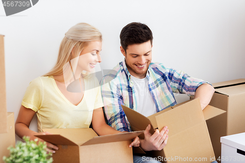 Image of happy couple unpacking boxes at new home