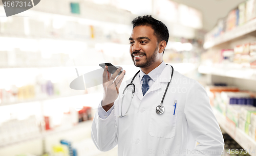 Image of indian male doctor recording voice by smartphone