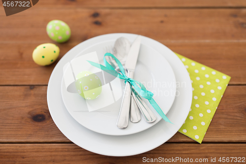 Image of easter egg in cup holder, plates and cutlery