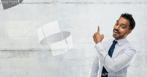 Image of indian businessman pointing finger at wall