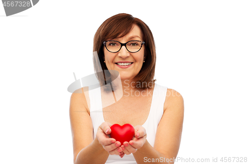 Image of portrait of smiling senior woman holding red heart